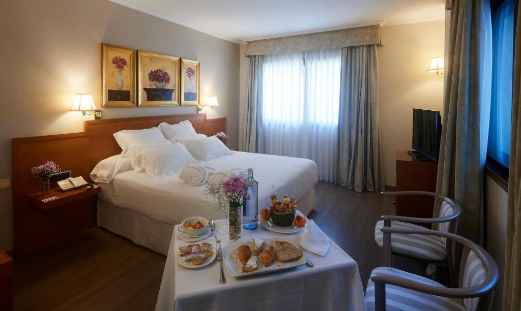 庞特维德拉加利西亚皇宫酒店的酒店客房,配有床和餐桌,上面有食物