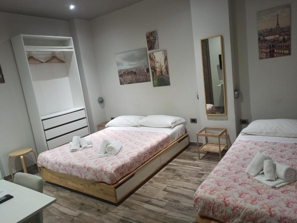 基耶蒂Le Mirage的一间卧室配有两张床、一张桌子和一面镜子