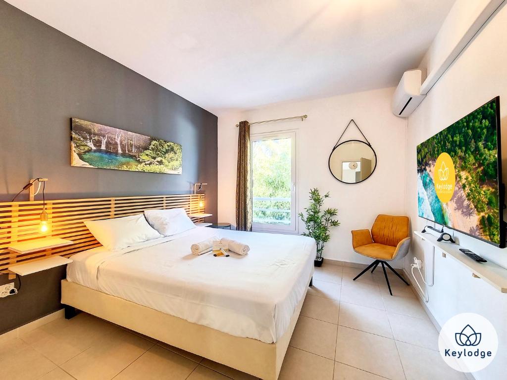 圣皮埃尔T3 - Tropical Lodge - 3 étoiles - 65m2 - Saint-Pierre的一间卧室配有一张床、一张书桌和一台电视。