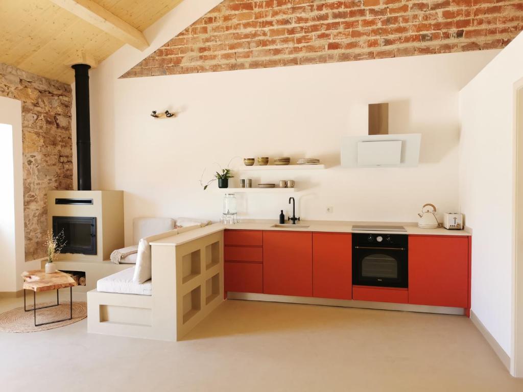 圣路易斯AL MAR Guesthouse的一间厨房,配有红色橱柜和砖墙