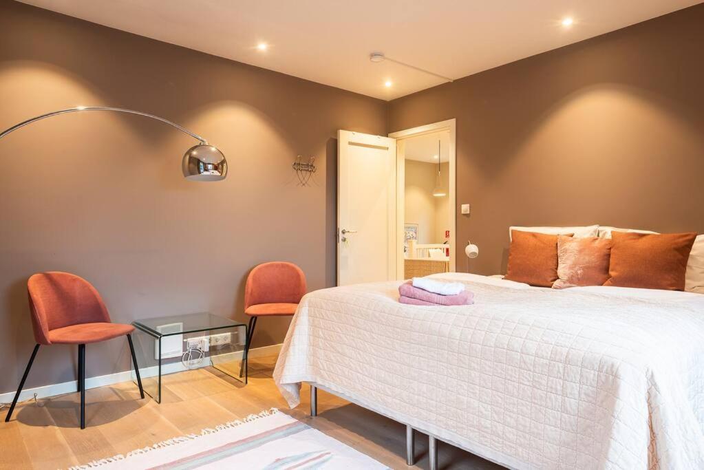 奥斯陆Cozy House的一间卧室配有一张床和两张橙色椅子