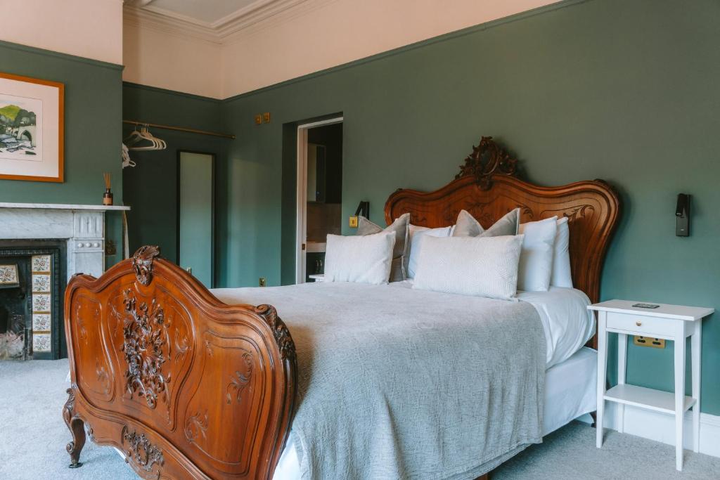 兰戈伦Riversdale House Bed & Breakfast的一间卧室设有一张大床和一个壁炉