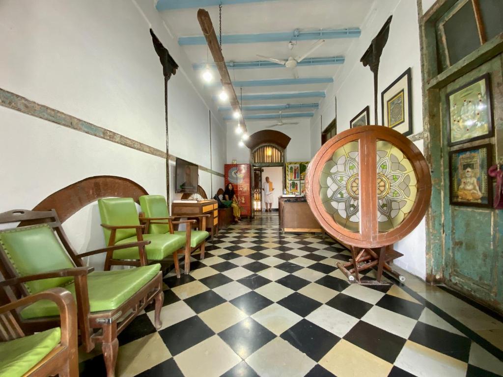 孟买瓦桑塔石兰姆孟买CST旅舍的一间设有绿色椅子和 ⁇ 板地板的等候室