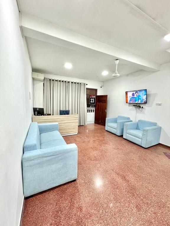 科伦坡KINGS HOTEL的客厅配有2张蓝色沙发和1台平面电视