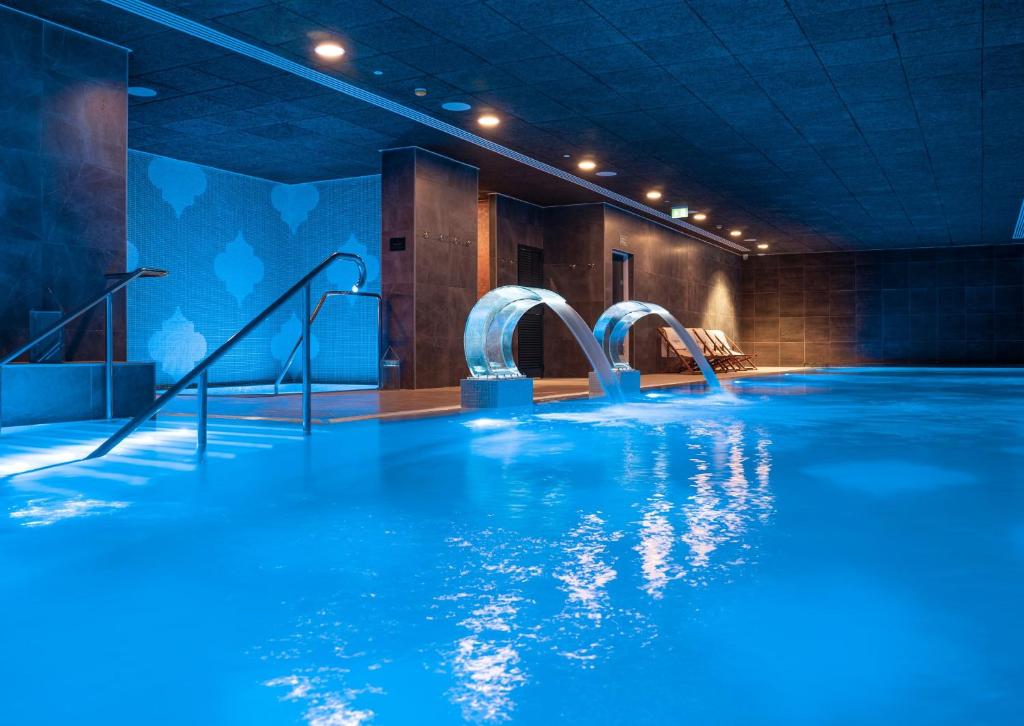 直布罗陀E1 Suites & Spa aparthotel style - Gym & Spa的一个带蓝色水和滑梯的游泳池