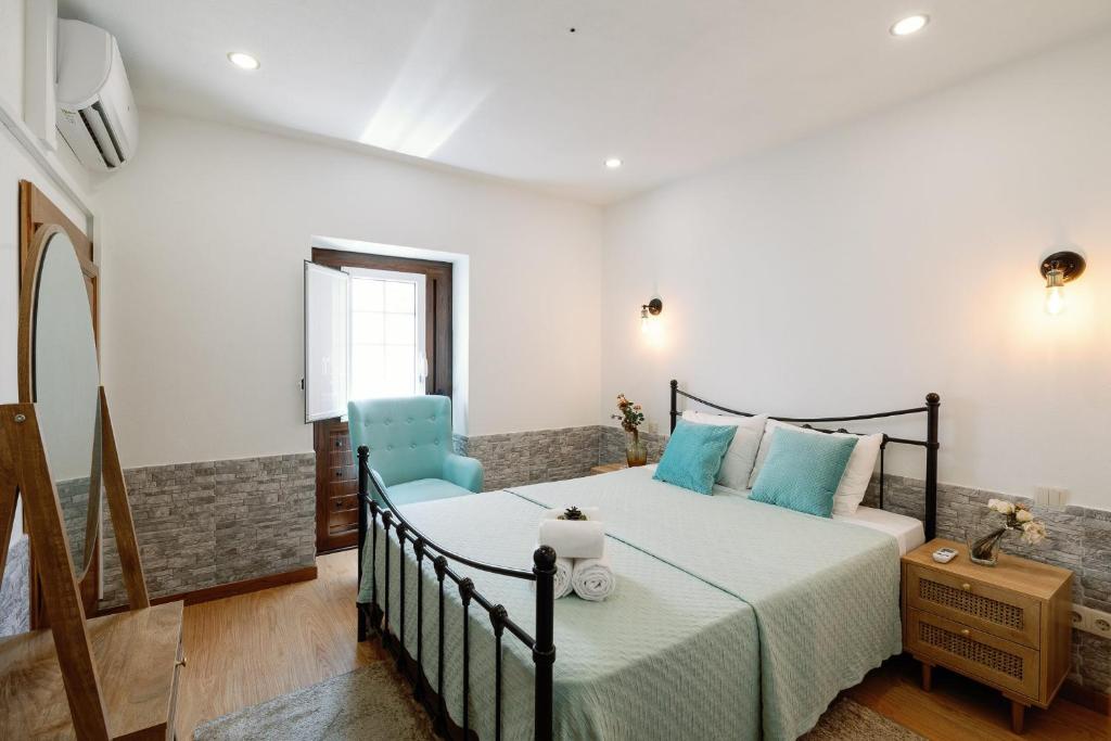 布拉干萨Casa do Javali的一间卧室配有一张床和一张蓝色椅子
