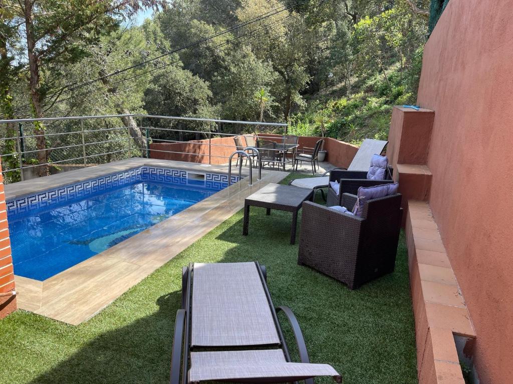 布拉内斯Villa for 2 families的后院设有游泳池和一些椅子