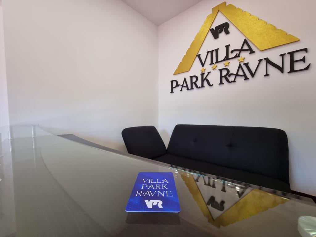 维索科Villa Park Ravne的大堂设有玻璃桌,上面有标志