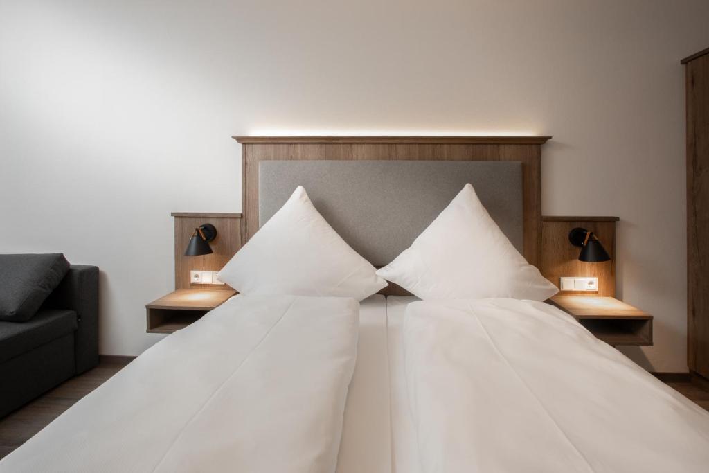 菲尔斯比堡Landgasthof Maier的一间卧室配有带白色床单和枕头的床。