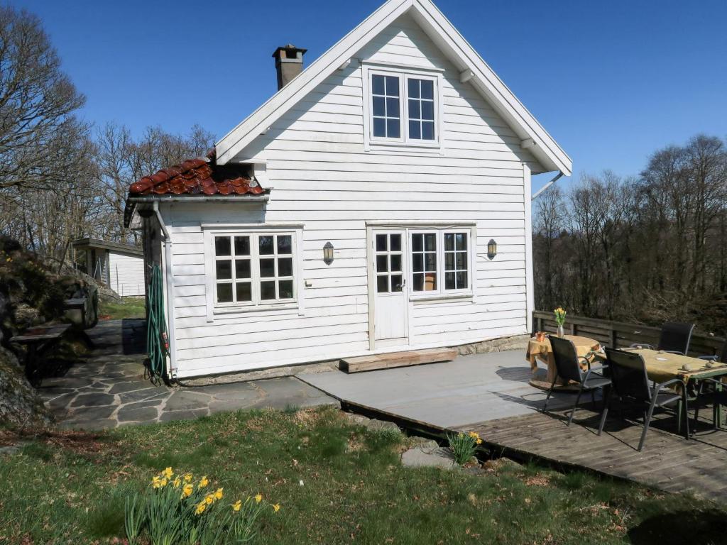 BekkjarvikHoliday Home Sjøhytta - FJH675 by Interhome的白色的房子,设有庭院和桌子