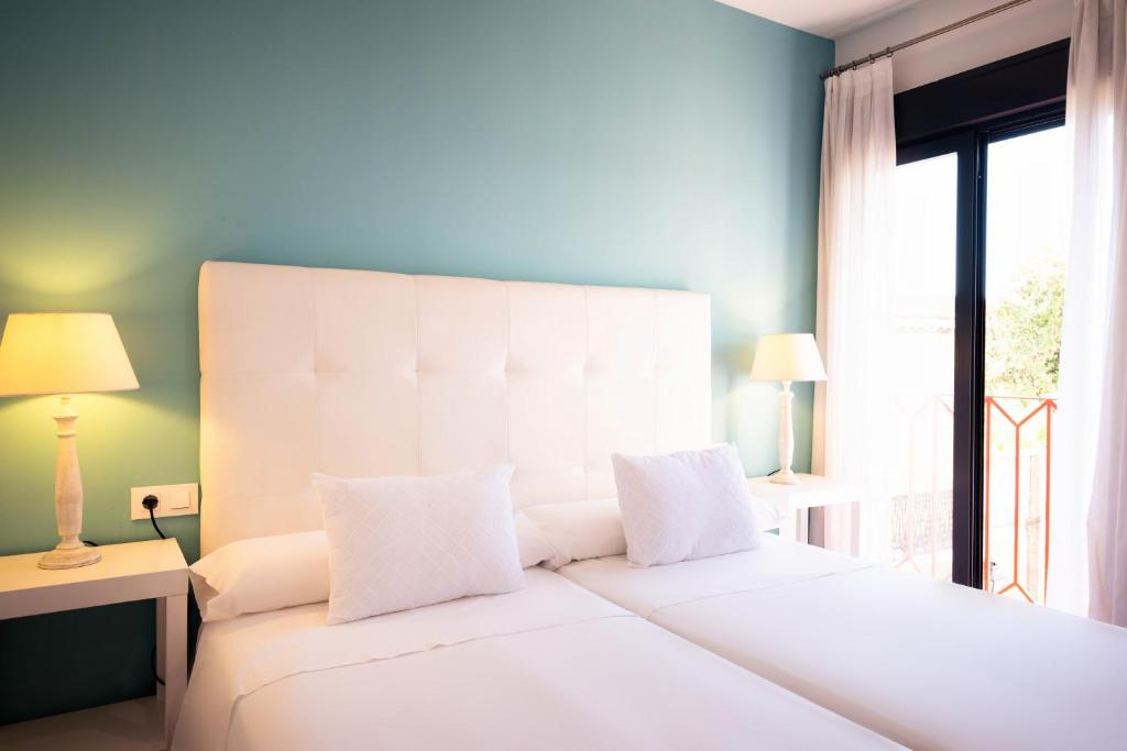 科尔多瓦Osario的卧室配有一张大白色床和窗户