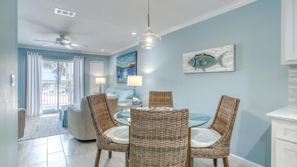德斯坦Poolside Villas 106 - Updated beachfront condo on Holiday Isle in Destin的有桌子和椅子的餐厅