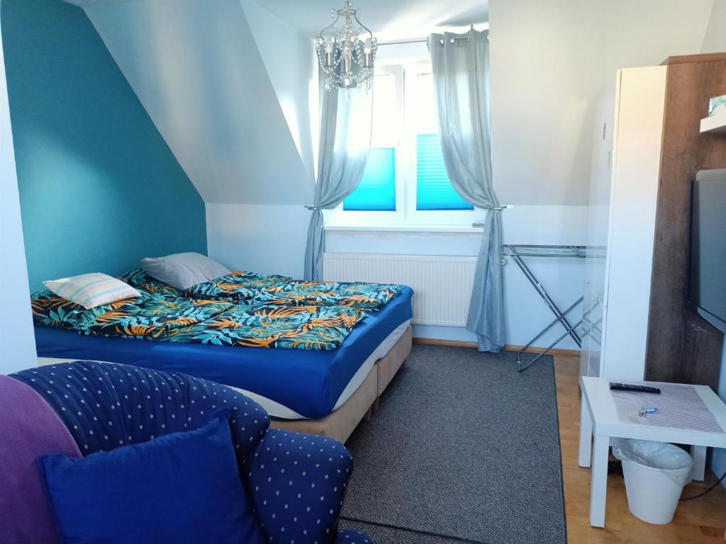 科沙林Bukowy zakątek kwatera prywatna的一间卧室配有一张床、一张沙发和一个窗口