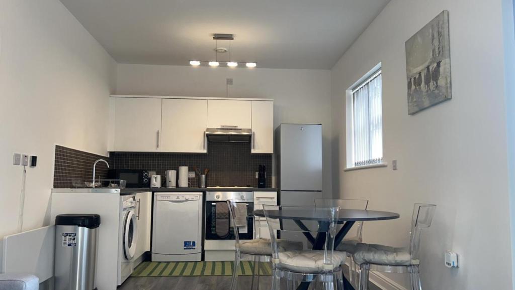 西布罗姆维奇Luxury apartment in dudley的厨房配有白色家电和桌椅