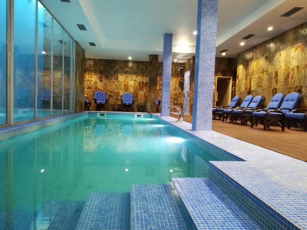 科英布拉壹贝爱瑞科酒店的一座带蓝色椅子的酒店游泳池
