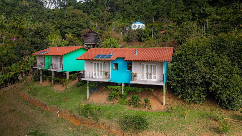 新文达移民镇Pousada Altoé da Montanha的享有三座红色屋顶房屋的顶部景致