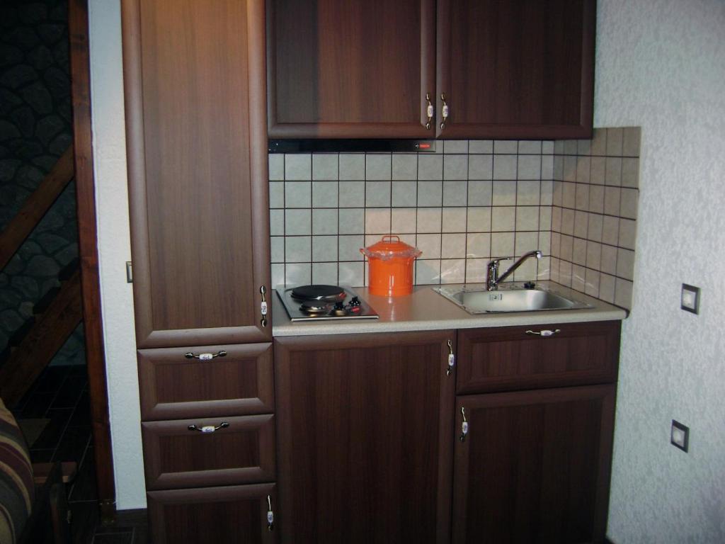 波利兹罗松PS Apartment Polydrosos - PS Rental的一个带木制橱柜和水槽的小厨房