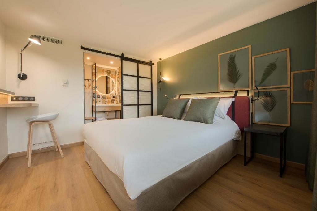 朱伊·奥克斯·阿奇斯钟楼梅兹鲁伊奥阿切酒店的卧室设有一张白色大床和绿色的墙壁