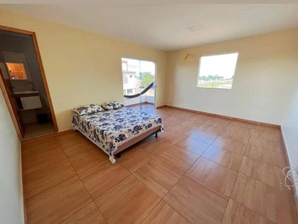 伊列乌斯Casa de Praia Pontal的一间卧室配有一张床,铺有木地板