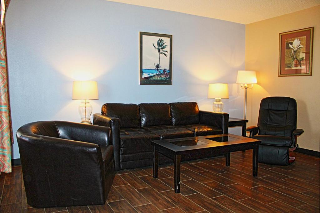 DonnaVictoria Palms Inn and Suites的客厅配有沙发和桌椅