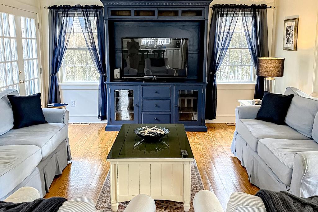 楠塔基特About Time的客厅配有两张沙发和一台电视机