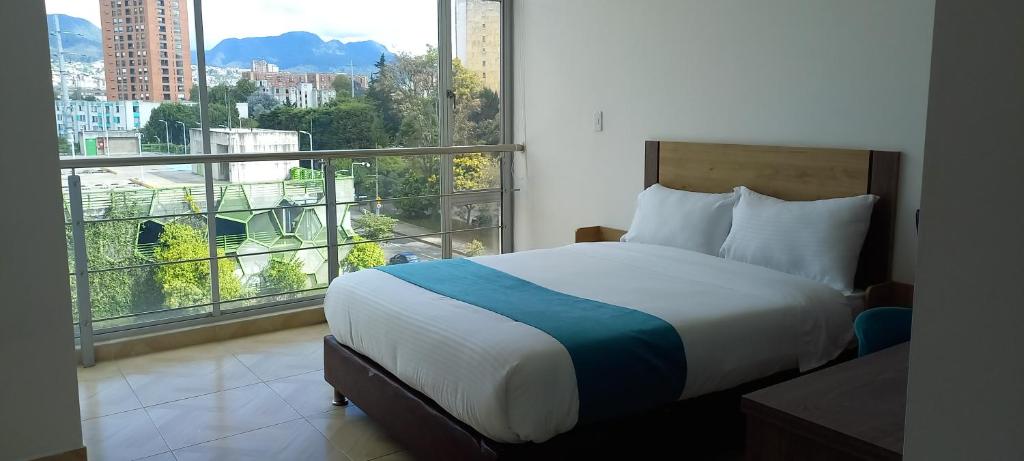 波哥大Hotel Royal Cid Bogota的一间卧室设有一张床和一个大窗户