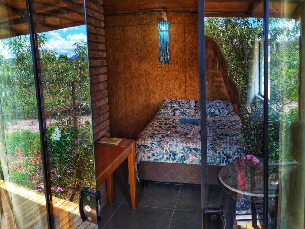 韦尔卡鲍Casa Raízes Capão的小房间设有一张床和一张桌子
