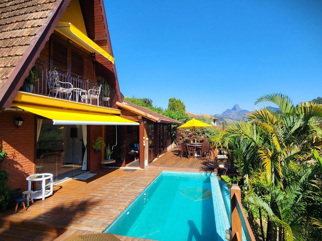 伊泰帕瓦Casa Serrana, 4 quartos com ar e piscina aquecida em meio à Natureza de Itaipava的一座带游泳池和庭院的房子