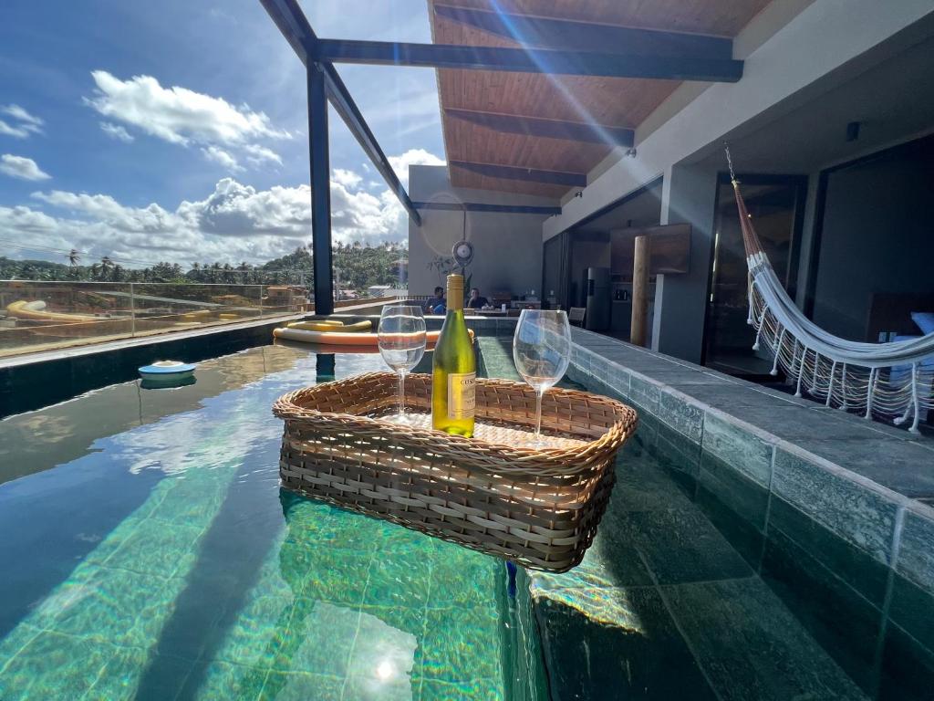 圣米格尔-杜斯米拉格里斯Kanui Mar (cobertura garden)的游泳池畔的一瓶葡萄酒和两杯酒