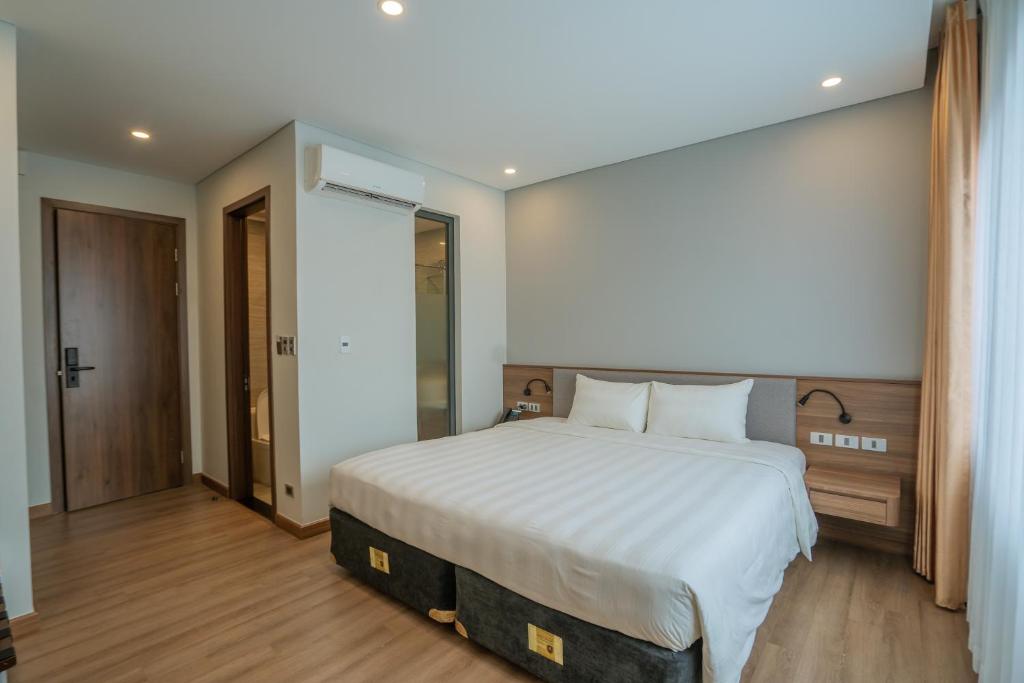 Uông Bí Boutique Hotel的一间卧室配有一张带白色床单的大床