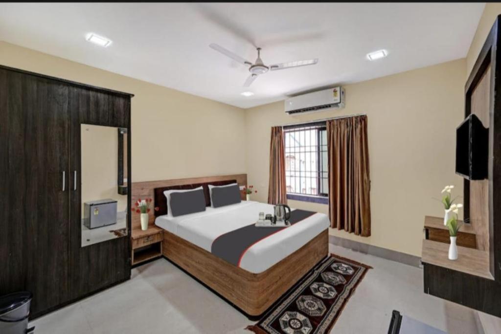 布巴内什瓦尔Goroomgo Moon Light Guest House Bhubaneswar Near Patia的一间卧室配有一张大床和电视