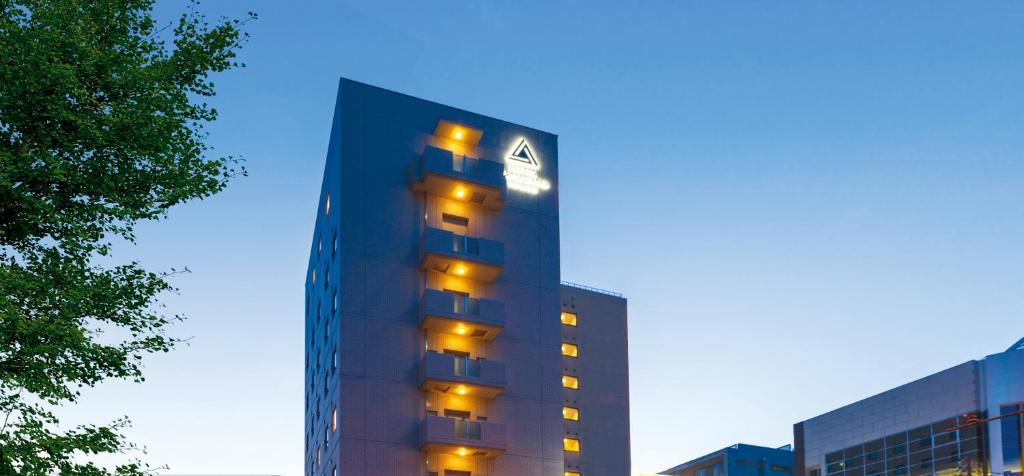 松山胜山甄选酒店的一座高大的建筑,旁边灯火通明