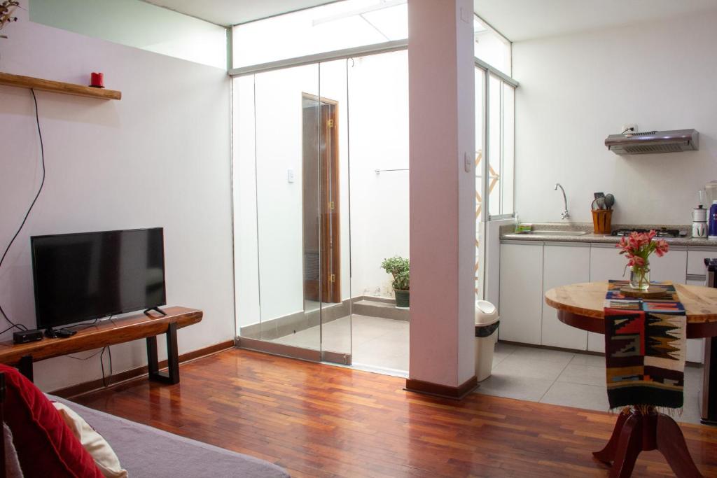 阿亚库乔Apartamento Altoandino的一间带电视和玻璃门的客厅