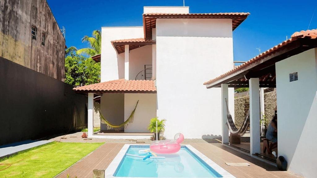 盖比姆Viva Guaibim: Casa de Praia com Piscina e Churrasqueira的游泳池里一座带粉红色猪的房子