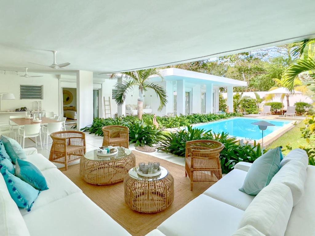 康隆尼角Villa White Horizon by Sealodge的开放式客厅配有白色家具和游泳池