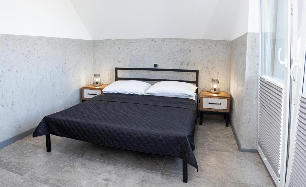 弗瓦迪斯瓦沃沃Domki MEGALO的一间卧室配有一张床和两个带灯的床头柜