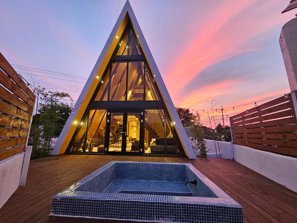 济州市Dongbok Sanjang Jeju的一座金字塔建筑,在甲板上设有热水浴缸