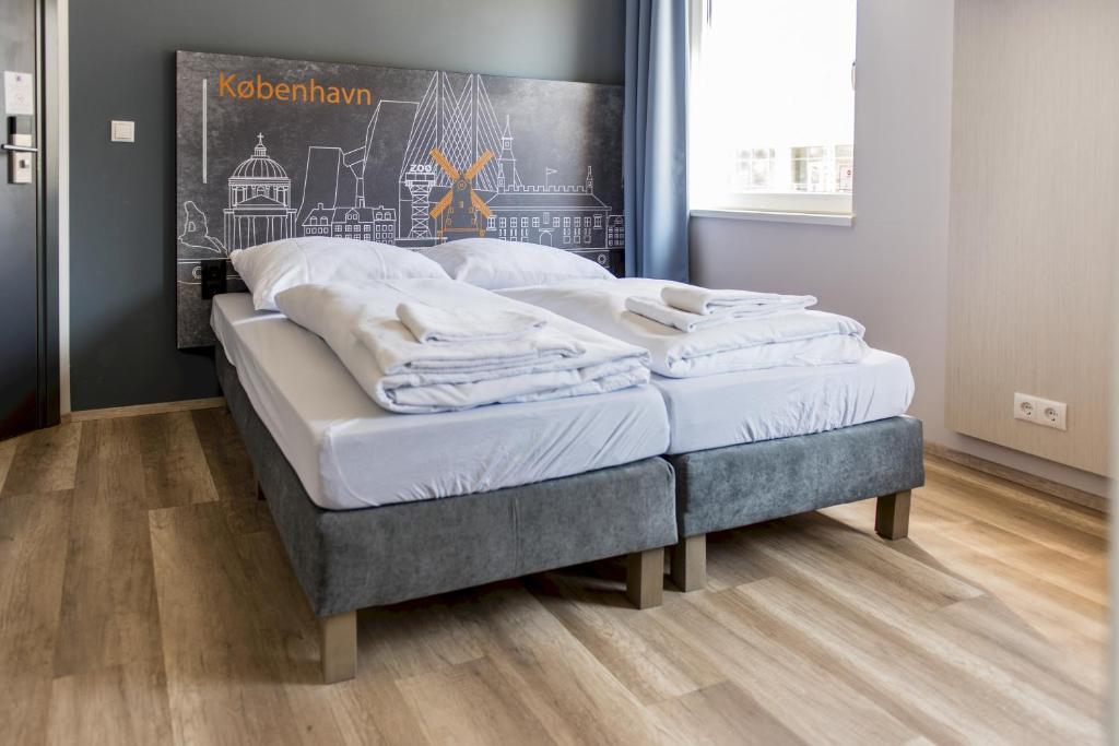 哥本哈根a&o Copenhagen Nørrebro的配有木地板的客房内的一张床铺