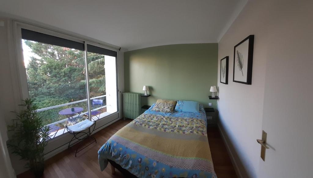 塞纳河畔埃皮奈Chambre d'hôte proche Paris的一间卧室设有一张床和一个大窗户