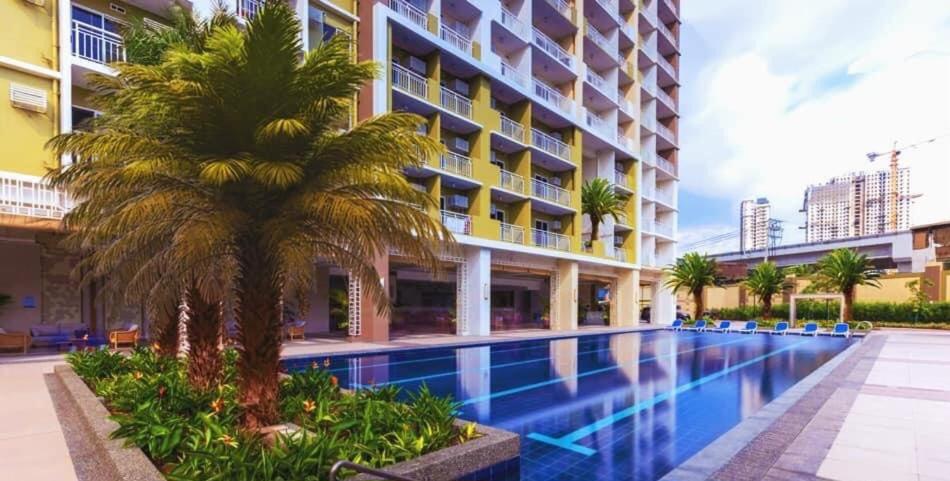 马尼拉Casa Concha by Celandine private residences的一座游泳池,旁边是一座棕榈树