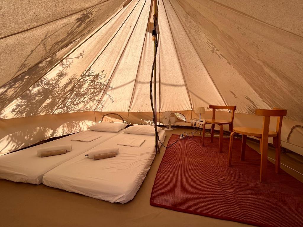 诺托La ViTa in land - between olives and almonds的帐篷内的一张床位,配有桌椅