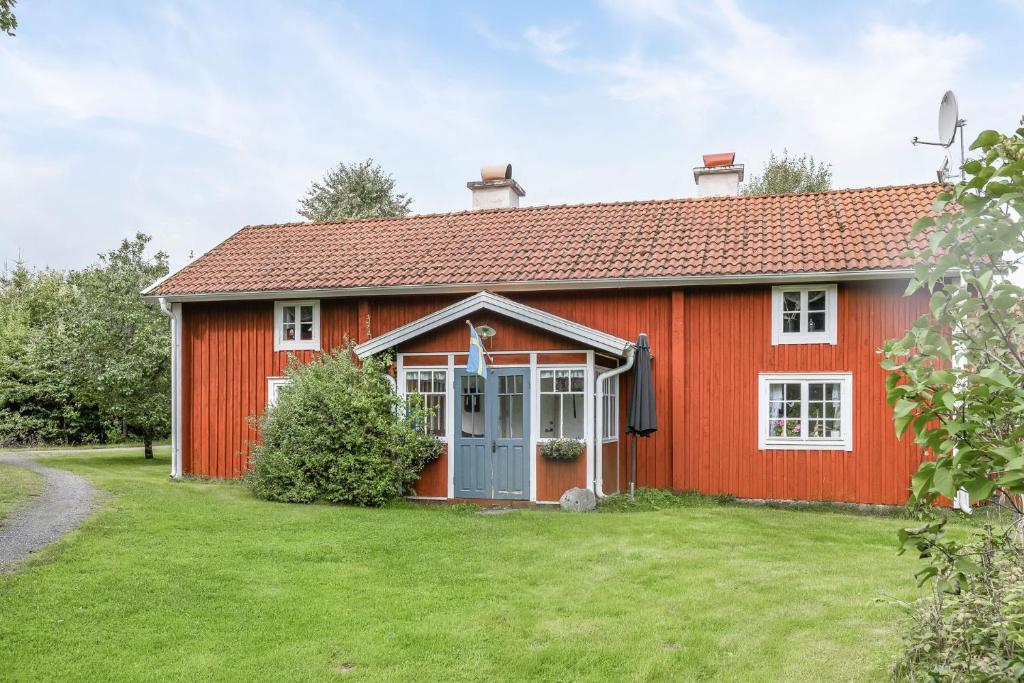 永比Nice cottage in Bolmstad outside Ljungby的绿色庭院的红色房子