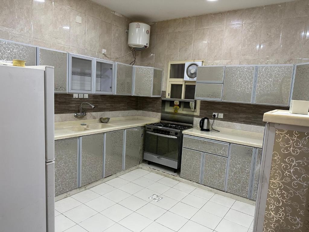 Sūq al Aḩadشقق فخمه的厨房配有白色家电和灰色橱柜