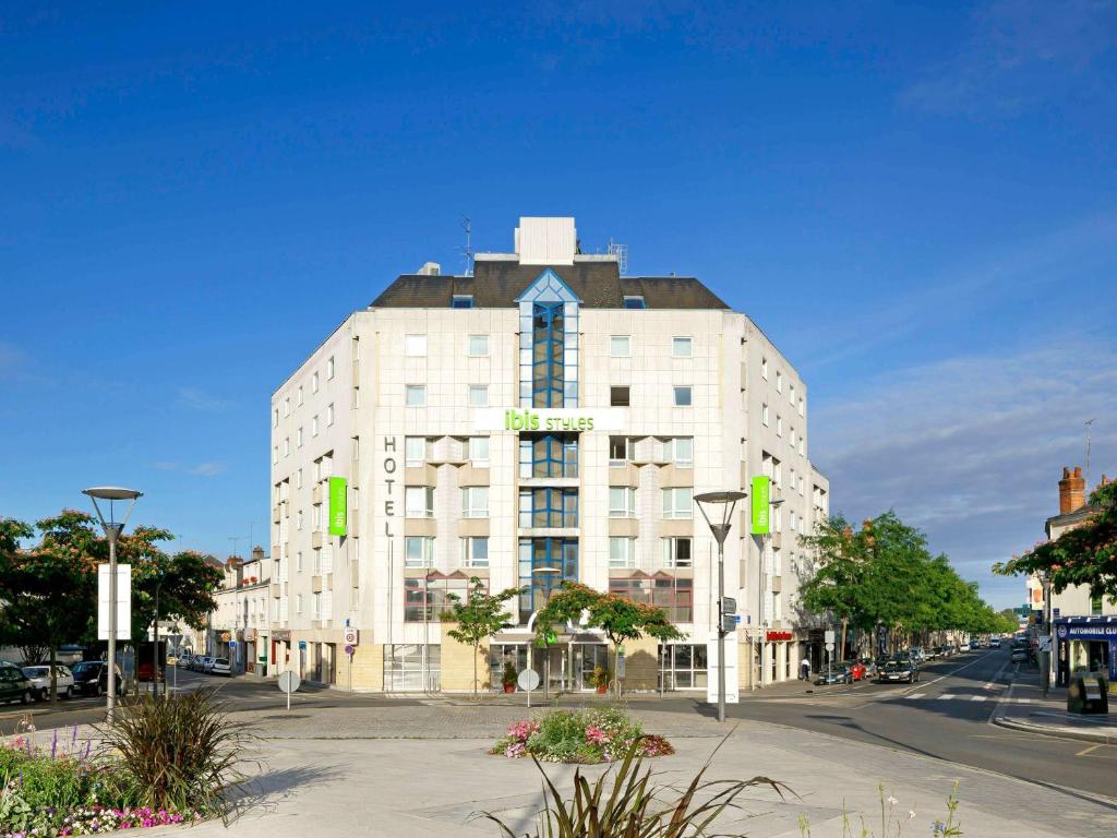 图尔风格旅游中心宜必思酒店的上面有绿色标志的高大的白色建筑