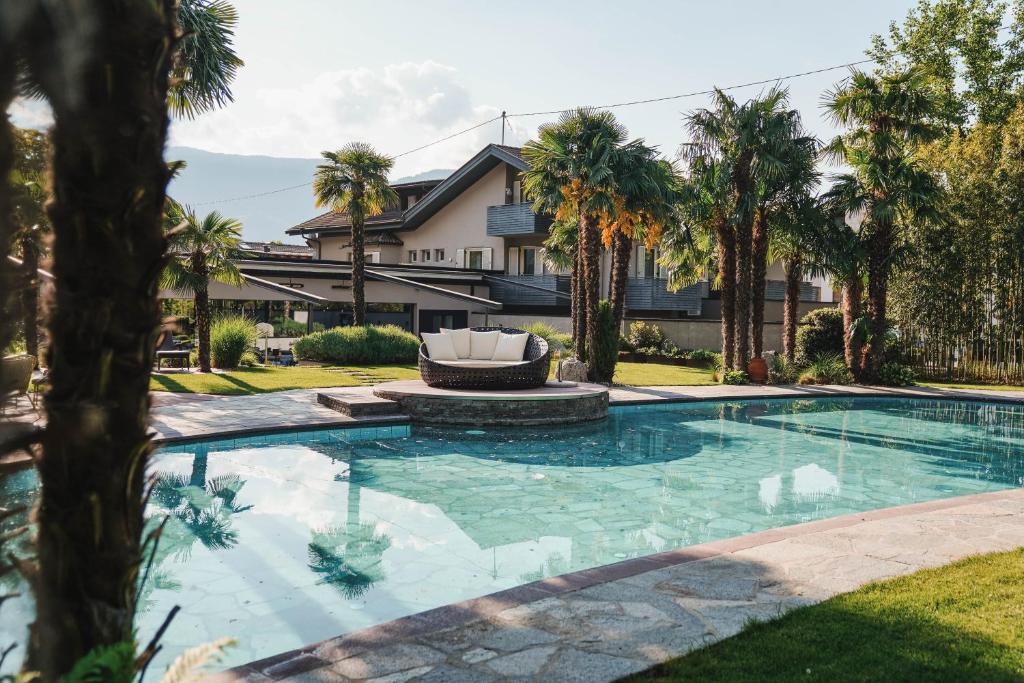 拉古多Hotel Dorner B&B的棕榈树屋前的游泳池
