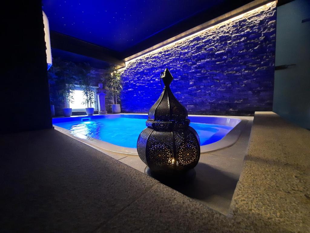 绍德方丹Le Clos des Thermes Suites de Luxe avec wellness privatif的游泳池旁的花瓶