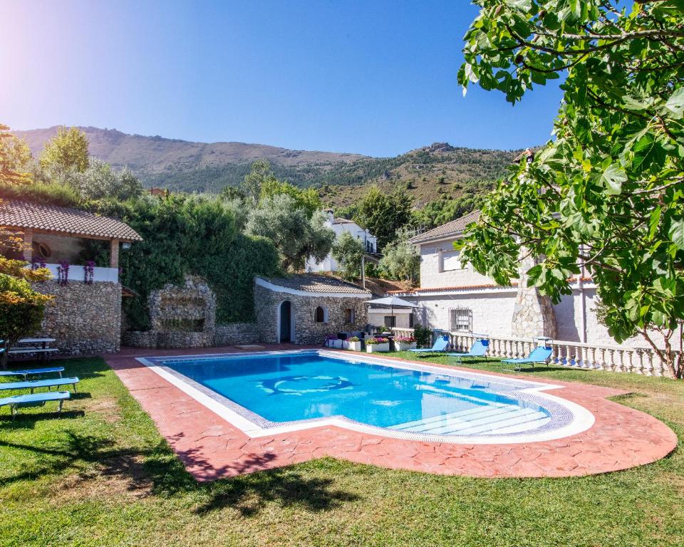哈恩Villa Fuji Sierra de la Pandera Jaén的一座带房子的庭院内的游泳池