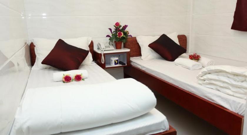 香港Relaince Inn的两张床位于带鲜花的房间
