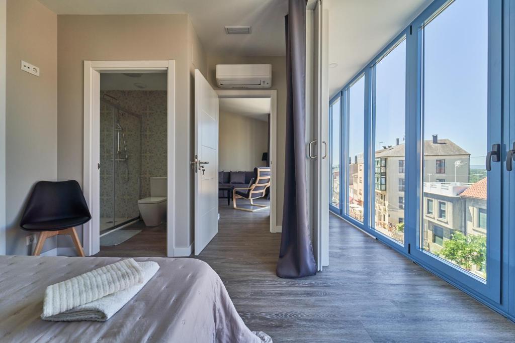 帕拉斯德丽Apartamentos Carballal的一间卧室设有一张床和一个大窗户