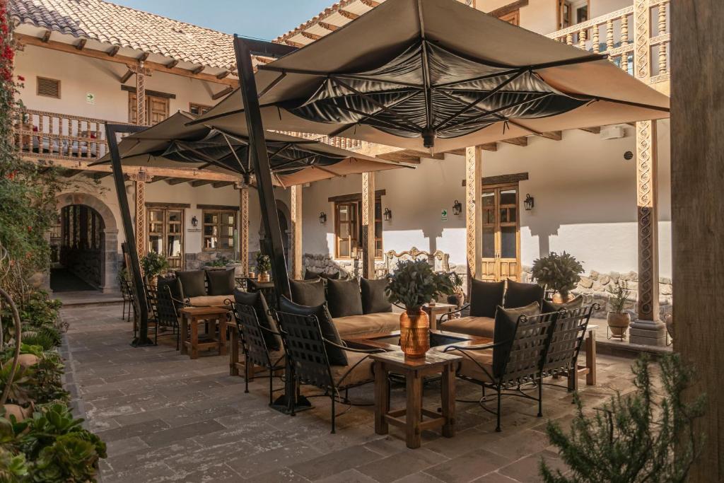 库斯科安提瓜卡索纳圣布拉斯酒店的一个带桌椅和遮阳伞的户外庭院。